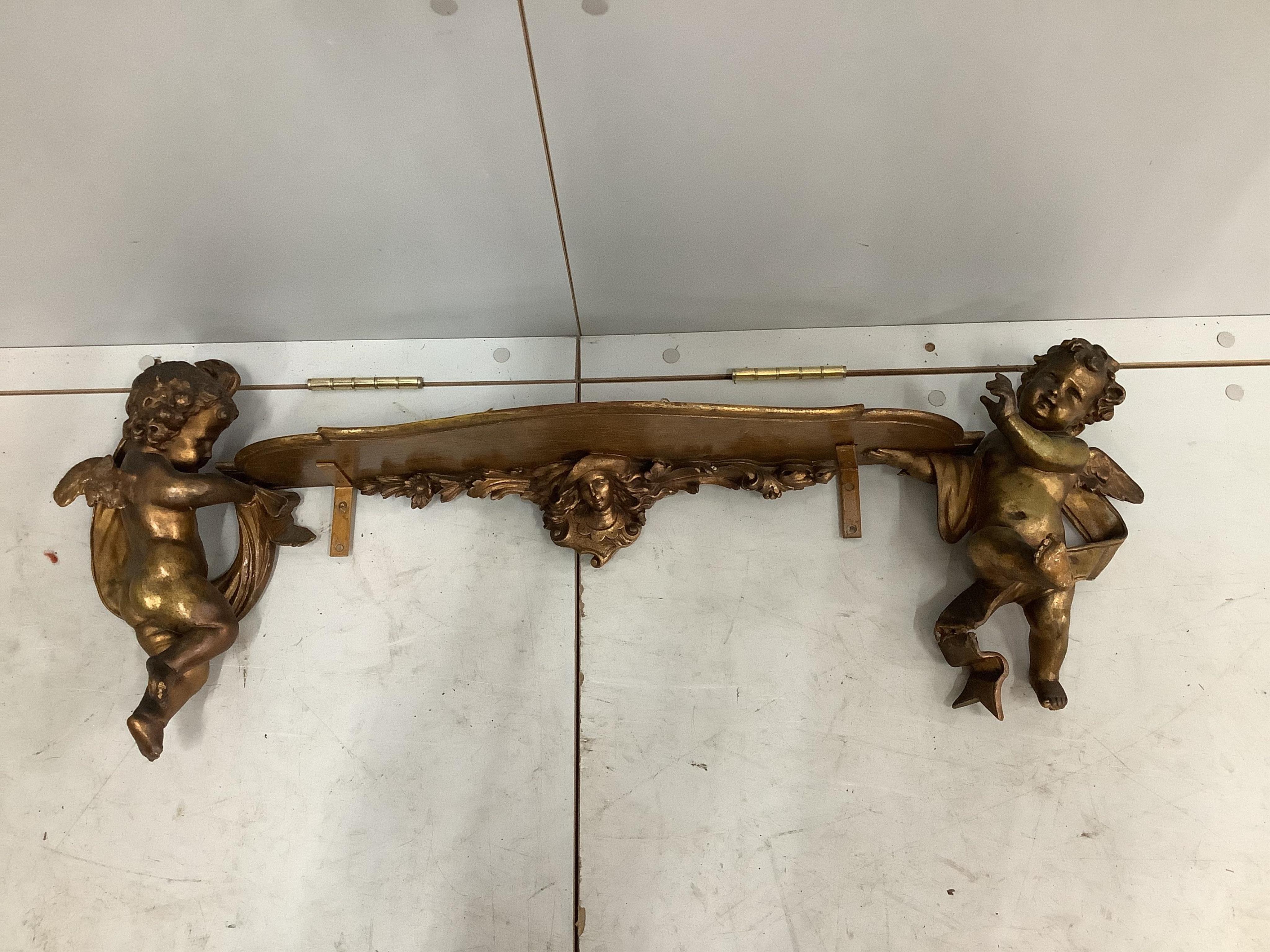 An 18th century style gilt composition cherub wall bracket, width 95cm. Condition - poor to fair